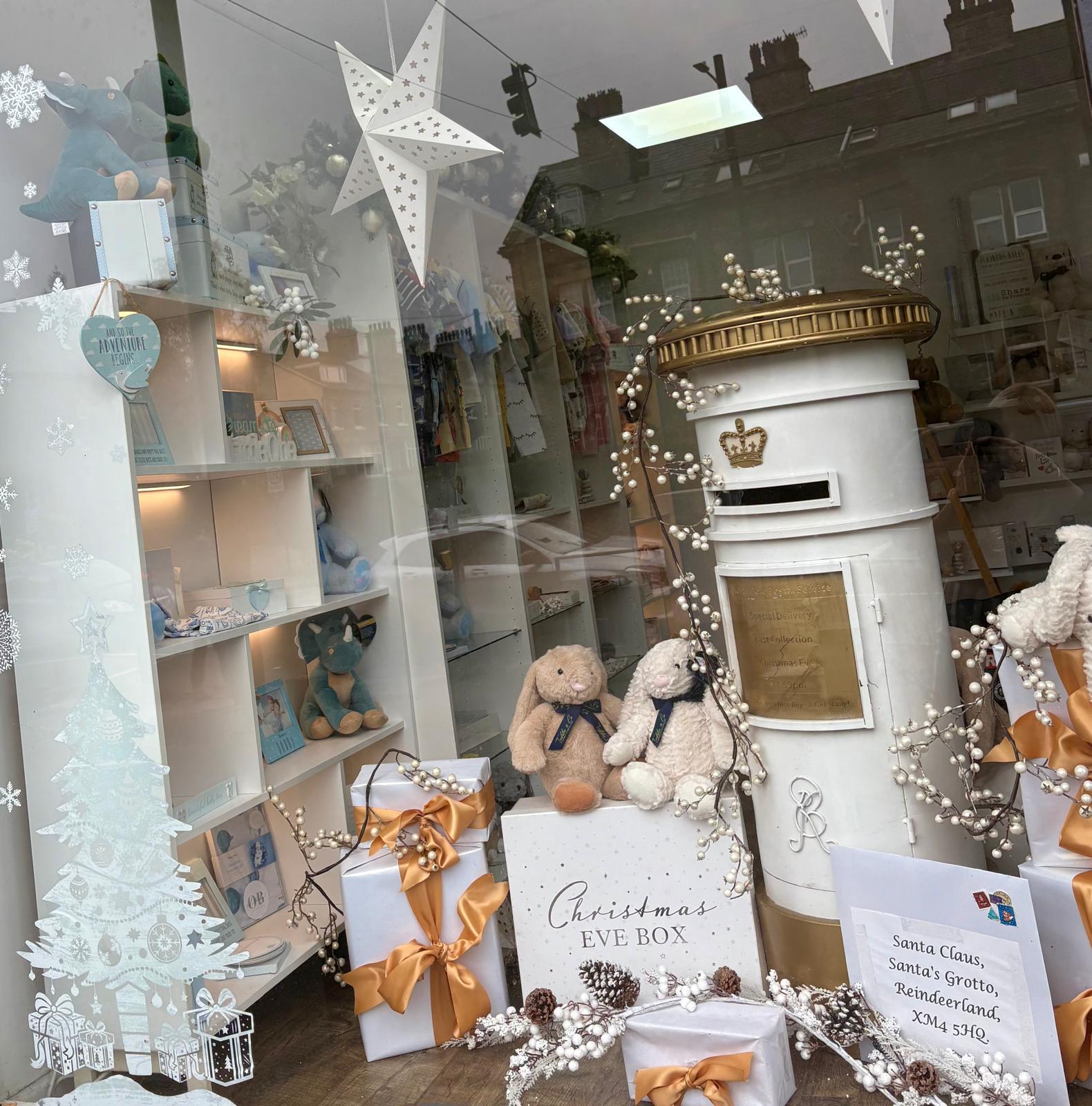 The Precious Glimpse window dressed for Christmas, with a Santa post box, Christmas Eve box and wrapped gifts