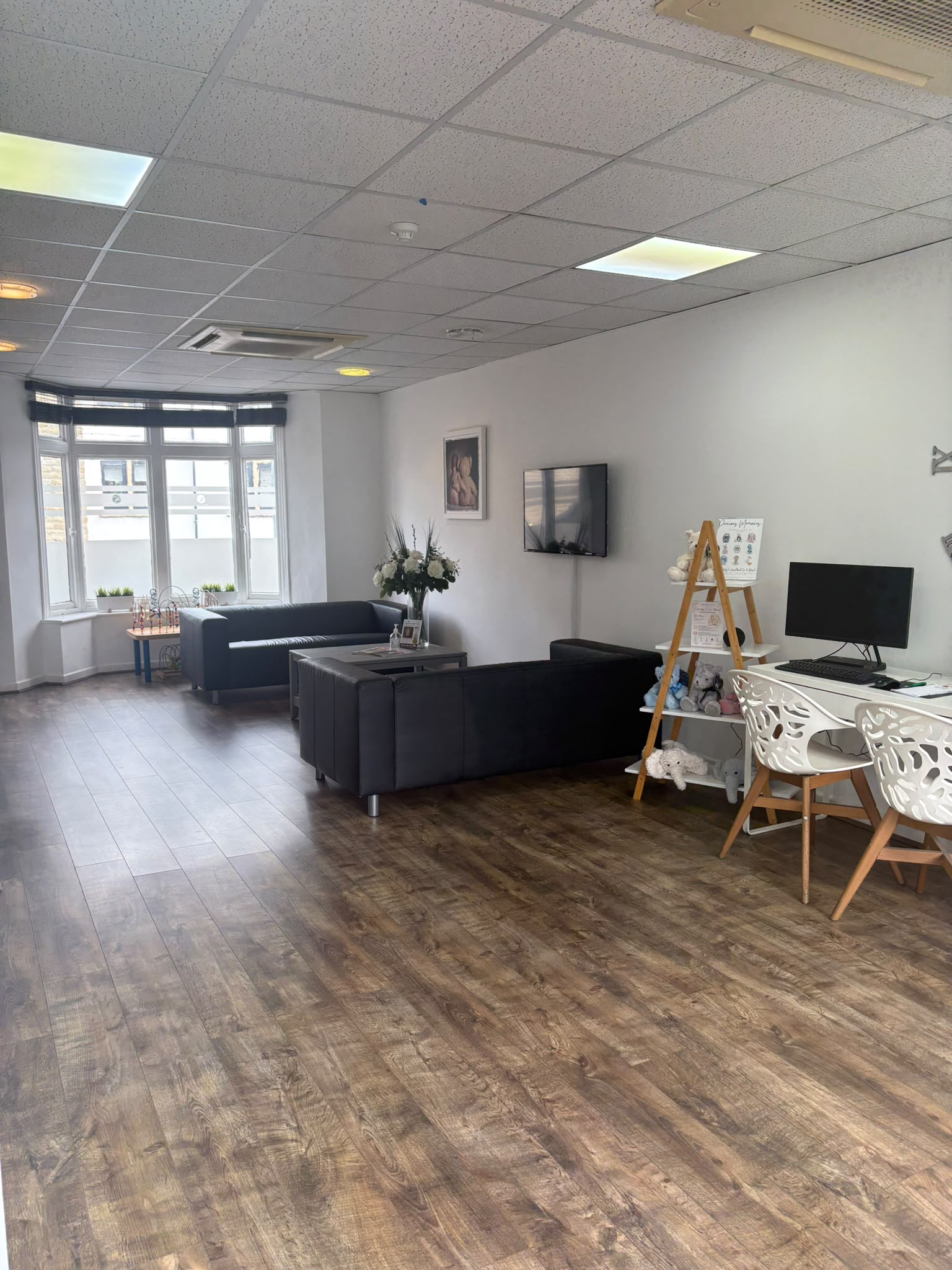 The main waiting room at Precious Glimpse, with sofas, a bay window and the reception desk