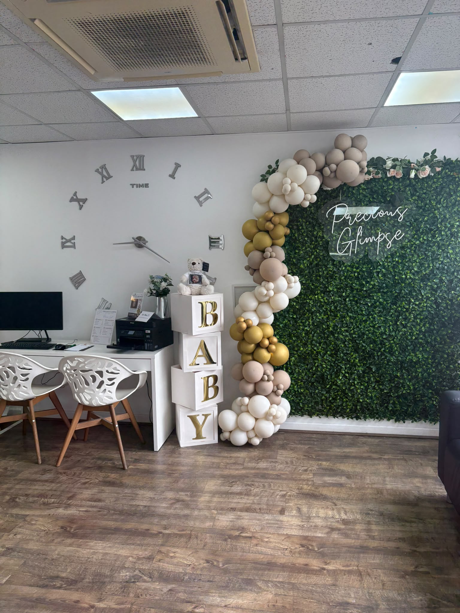 The Precious Glimpse flower wall and neon sign beside the reception desk, dressed with balloons